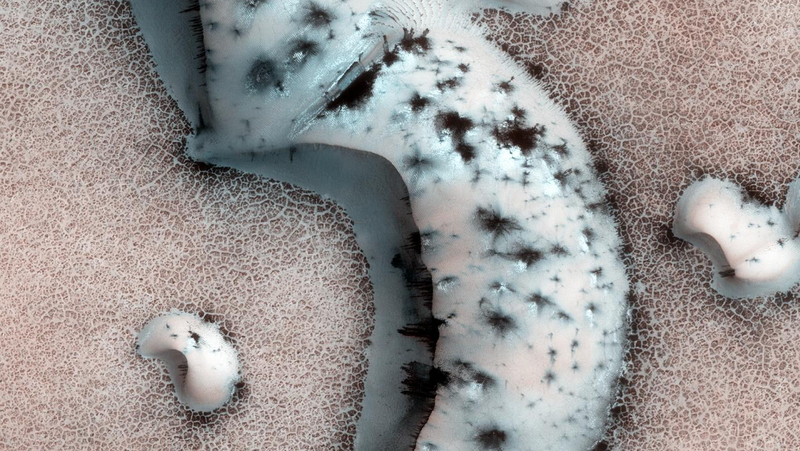 Image of a Martian polar cap with dark pockets of warming due to trapped carbon dioxide
