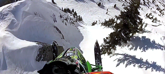 Watch this snowmobile launch off a cliff and feel your stomach drop