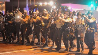 Law-enforcement officers watch during a protest on West Florissant Avenue in Ferguson, Mo., on Aug. 18, 2014, in the wake of the fatal police shooting of Michael Brown. Michael B. Thomas/AFP/Getty Images