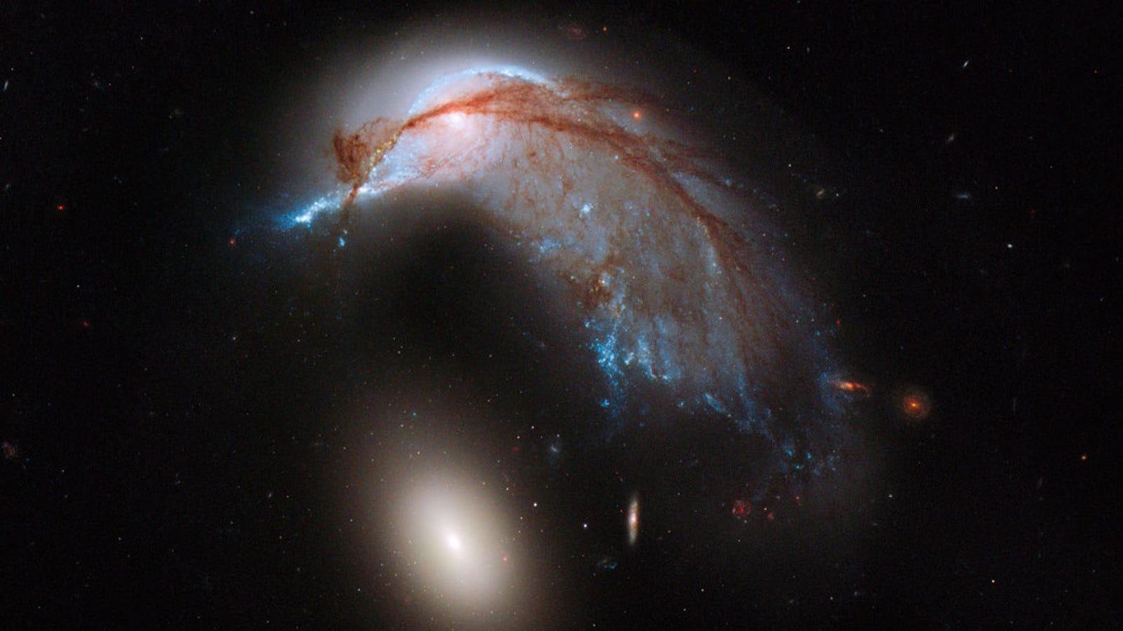 Colliding galaxies take on the shape of a penguin guarding its egg