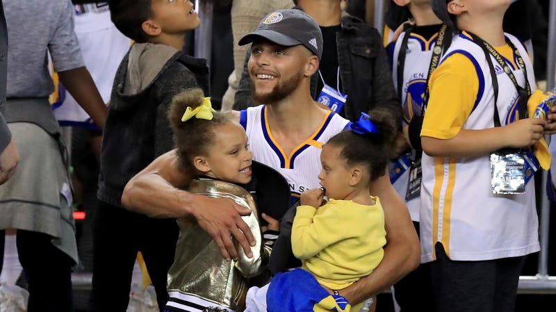 Stephen Curry of the Golden State Warriors celebrates holding daughters Riley and Ryan after defeating the Cleveland Cavaliers 129-120 in Game 5 to win the 2017 NBA Finals on June 12, 2017 in Oakland, California.