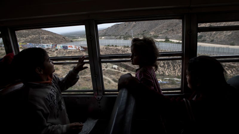 Central American children who are traveling with a caravan of migrants, look at the border wall from a bus carrying the group to a gathering of migrants living on both sides of the border, in Tijuana, Mexico, Sunday, April 29, 2018.