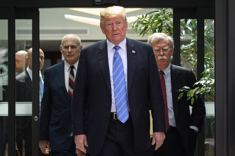 President Donald Trump (C) leaves with Chief of Staff John Kelly (L) and National Security Adviser John Bolton (R) after holding a press conference ahead of his early departure from the G7 Summit on June 9, 2018 in La Malbaie, Canada.