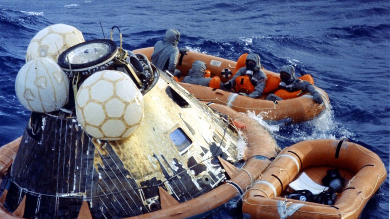 The Apollo 11 astronauts, in orange, being disinfected upon successfully returning back to Earth and landing in the Pacific ocean.