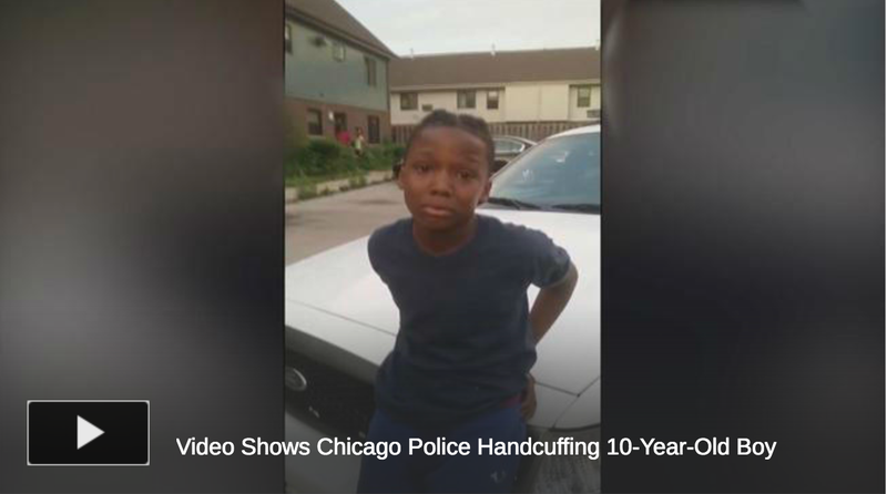 A 10-year-old identified as Michael Thomas Jr. is cuffed by police as an outraged community looks on.