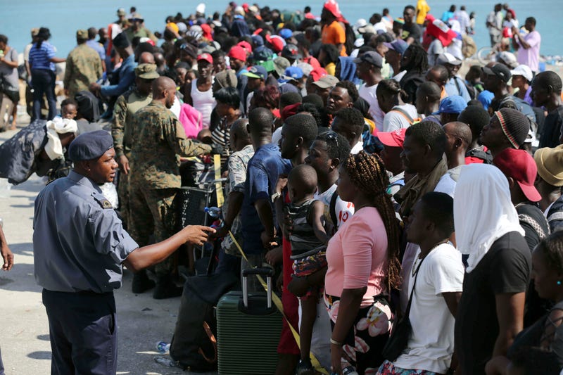 A Bahama’s Army officer speaks with people evacuated prior boarding a ferry to Nassau at the Port in Marsh Harbor, Abaco Island, Bahamas, Saturday, Sept. 7, 2019.
