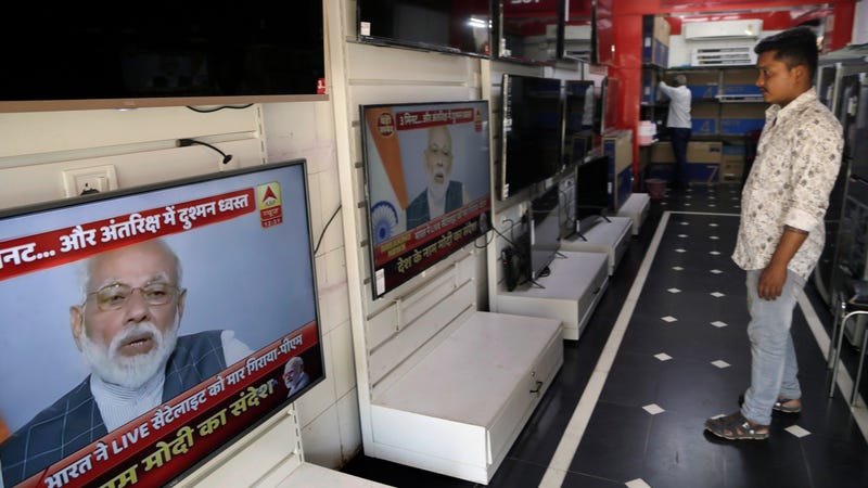 A salesperson watches Indian prime minister Narendra Modi addressing the nation on a television in Mumbai, India, March 27, 2019.