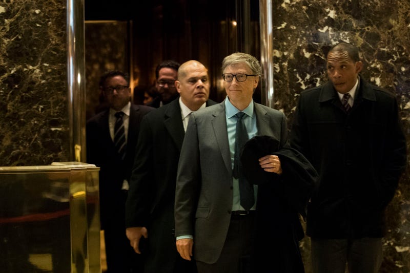 Bill Gates (front, left) exits an elevator before speaking to reporters at Trump Tower in New York City on Dec. 13, 2016.