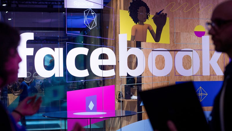 Conference workers speak in front of a demo booth at Facebook’s annual F8 developer conference.