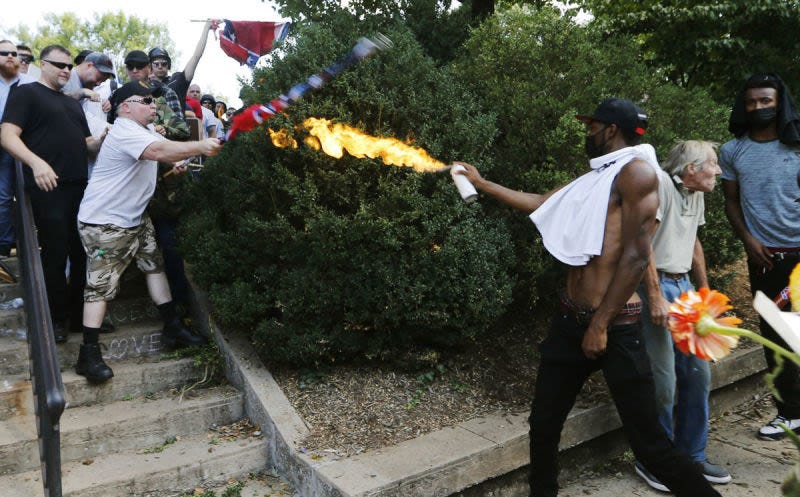 Corey Long uses spray paint can against white supremacists in the Unite the Right rally in Charlottesville, Va., on Aug. 12, 2017.