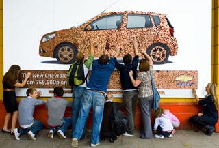 Illustration for article titled Chevy Aveo Billboard Makes Cents, Weighs Untold Pounds