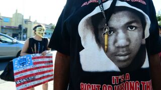 A man wears a single bullet around his neck over his Trayvon T-shirt at a rally in Los Angeles. (Frederic J. Brown/Getty Images)