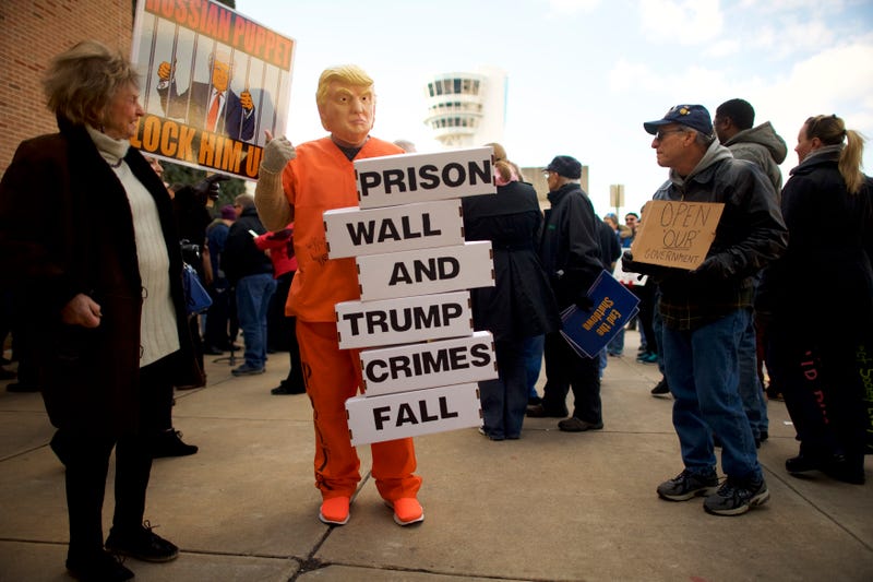 A protester dressed as President Donald Trump holds a placard stating ‘PRISON WALL AND TRUMP CRIMES FALL’ while demonstrating with Philadelphia Airport TSA and airport workers outside the Philadelphia International Airport on January 25, 2019 in Philadelphia, Pennsylvania. The government shutdown, now lasting 35 days, is the longest in United States history, affecting about 800,000 federal employees.