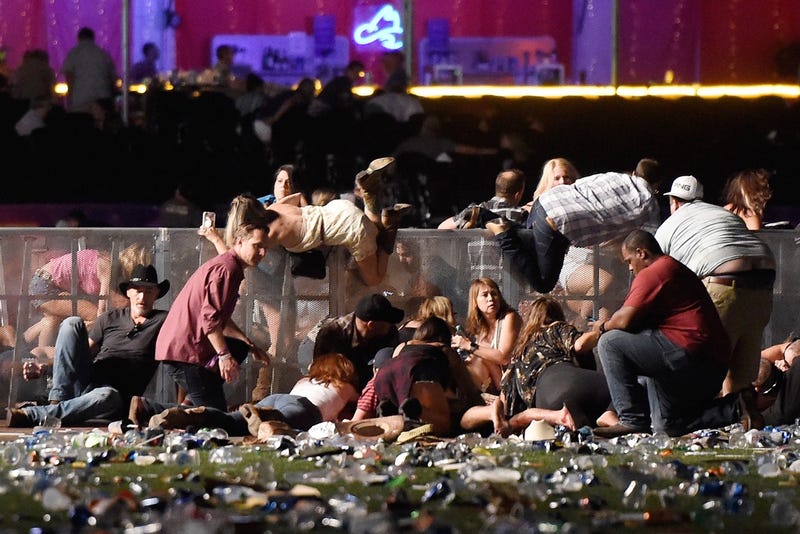 People scramble for shelter at the Route 91 Harvest country music festival after apparent gun fire was heard on October 1, 2017 in Las Vegas, Nevada. (Photo by David Becker/Getty Images)