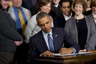 President Barack Obama signs a presidential memorandum increasing workers’ overtime protections during an event in the East Room of the White House, March 13, 2014.SAUL LOEB/AFP/Getty Images