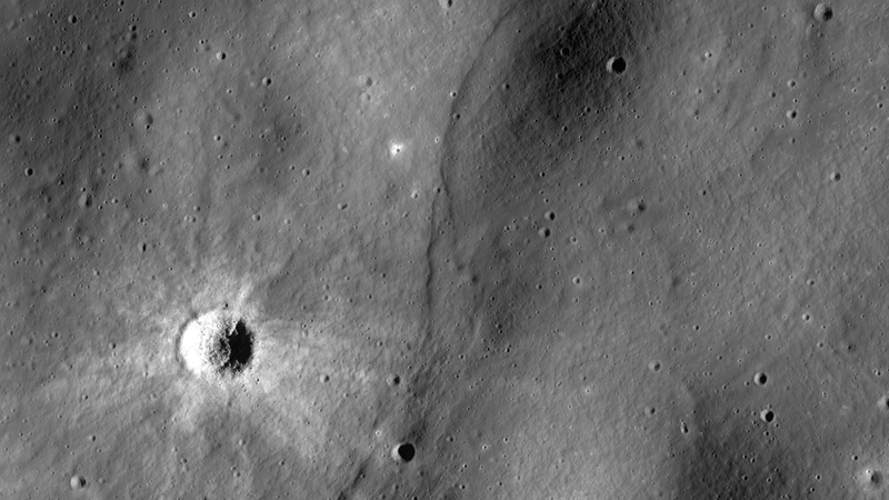 A lobate scarp, a potential lunar fault line, bisects this image.