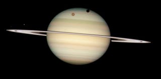 Illustration for article titled Hubble Captures Four Moons Transiting In Front Of Saturn!