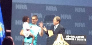 Elaih Wagan's father holds her at the NRA convention. (Twitter)