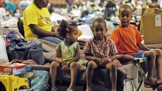 Hurricane Katrina evacuees sit on cots Sept. 6, 2005, on the floor of the Astrodome in Houston.  STAN HONDA/AFP/Getty Images