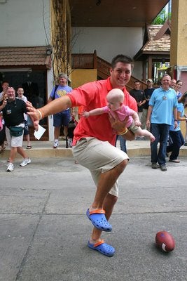 Illustration for article titled Tim Tebow Is Touching Babies in Asia Again