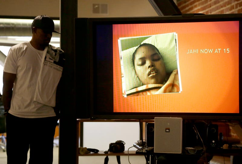 A photo of Jahi McMath is shown on a video screen next to her uncle Timothy Whisenton at a news conference in San Francisco on Dec. 23, 2015.