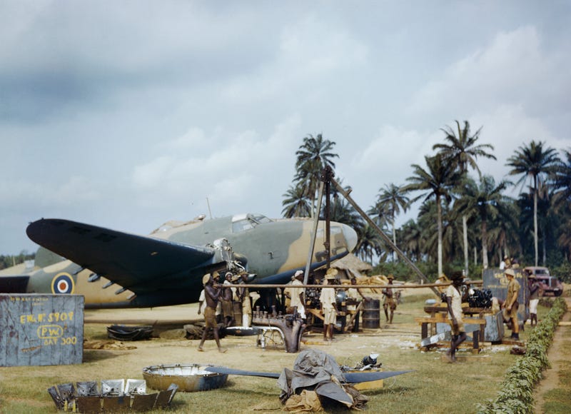 Pekerja lokal membantu petugas RAF mengganti mesin Lockheed Hudson di Yundum di Gambia, April 1943.