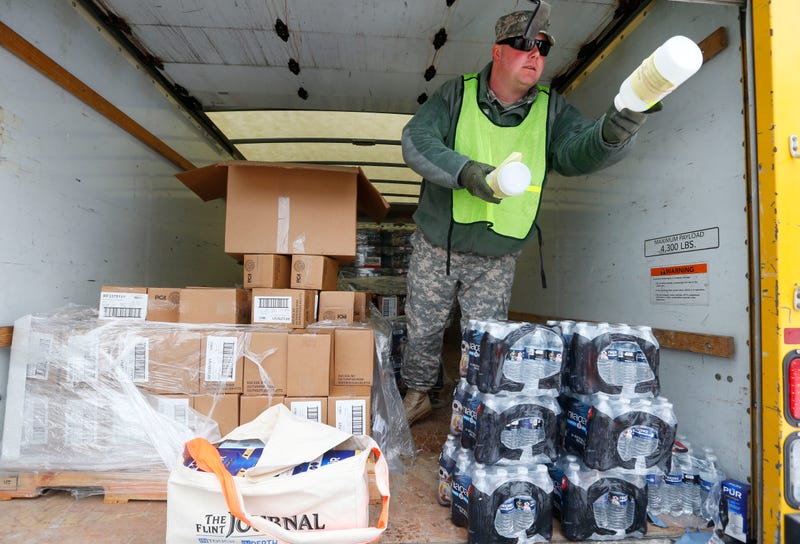 Michigan National Guard Staff Sgt. James Green hands out a water test kit to be distributed to residents Jan. 21, 2016, in Flint, Mich.