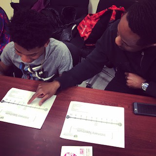 Officer Charles helping participant Jerome with his homework (Dana Rachlin/NYC Together)