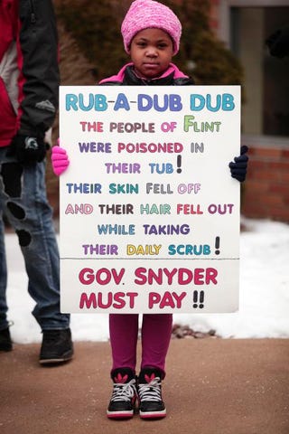 XyNazia Skinner, age 7, of Flint, Mich., stands with a sign while waiting to participate in a march in Flint to highlight the push for clean water in the city Feb. 19, 2016. Bill Pugliano/Getty Images