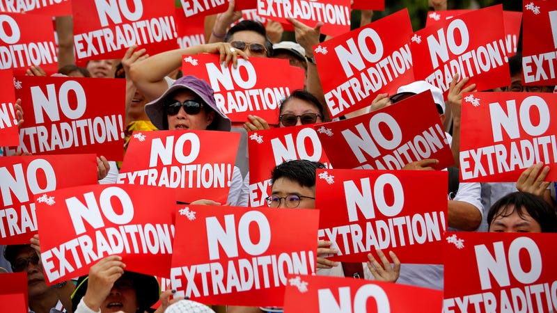 Protesters hold placards as they stage protest an extradition law in Hong Kong on June 9, 2019