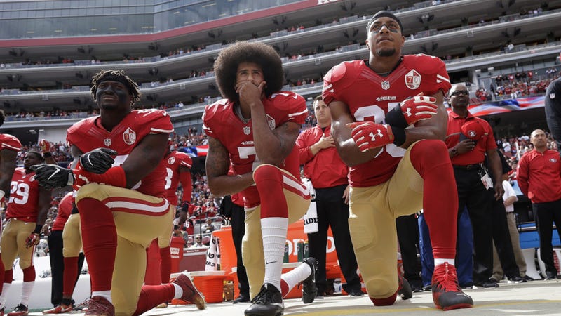 Colin Kaepernick, center, takes a knee during the national anthem, sparking a national debate about athletes and social activism.