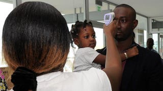 A doctor at the National Public Health Institute takes the temperature of a man at the airport in Ivory Coast Aug. 13, 2014, as part of protective measures against the Ebola virus.SIA KAMBOU/Getty Images