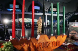 Camille Yarborough sings African music in view of a traditional kinara during a news preview of a Kwanzaa festival held at New York’s American Museum of Natural History on Dec. 22, 2004.Mario Tama/Getty Images