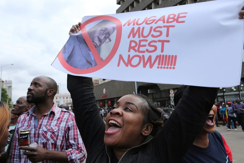 A woman holds up a banner among crowds marching on the streets of Harare, Zimbabwe, on Nov. 18, 2017, demanding the departure of President Robert Mugabe. (Tsvangirayi Mukwazhi/AP Images)
