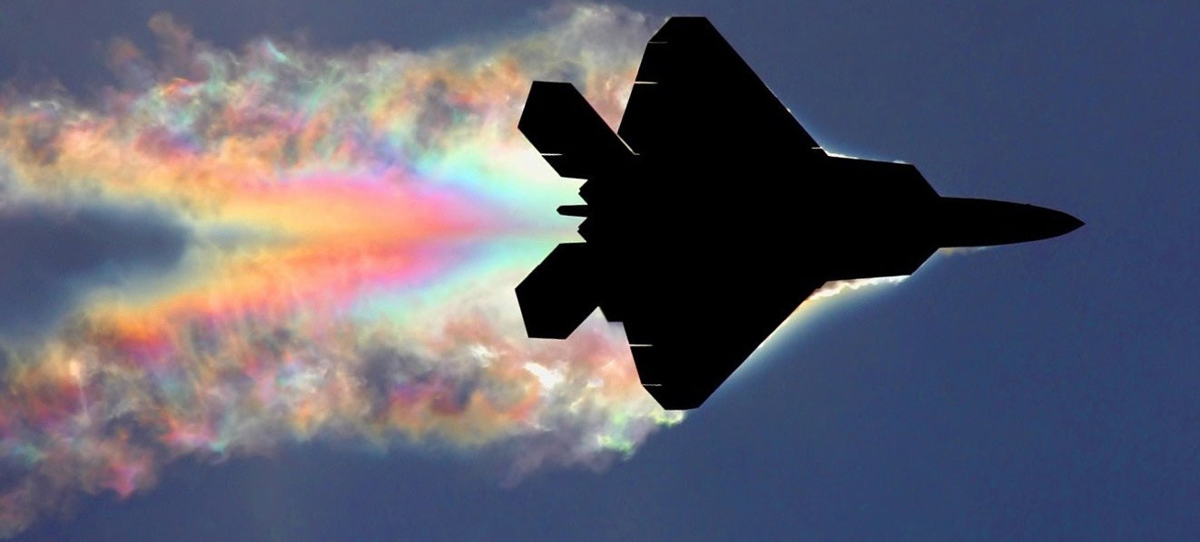 F-22 Raptor Makes A Rainbow As Sunlight Diffracts On Its Vapour Trail