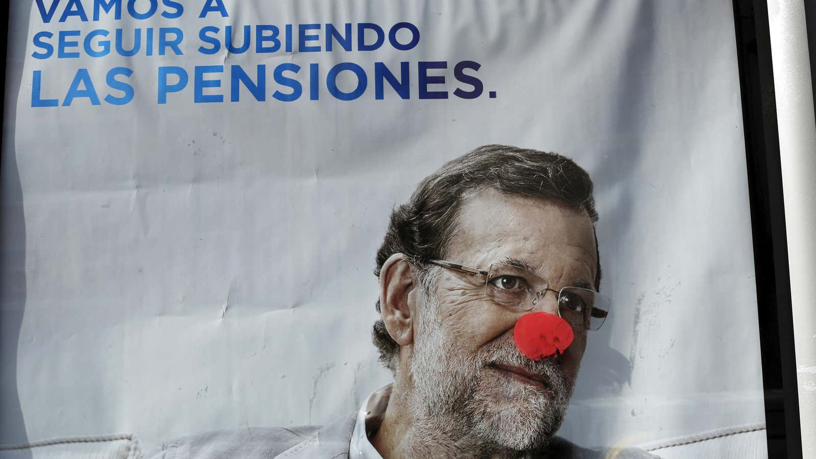 A defaced campaign poster of Spanish Prime Minister and ruling People’s Party (PP) leader Mariano Rajoy.