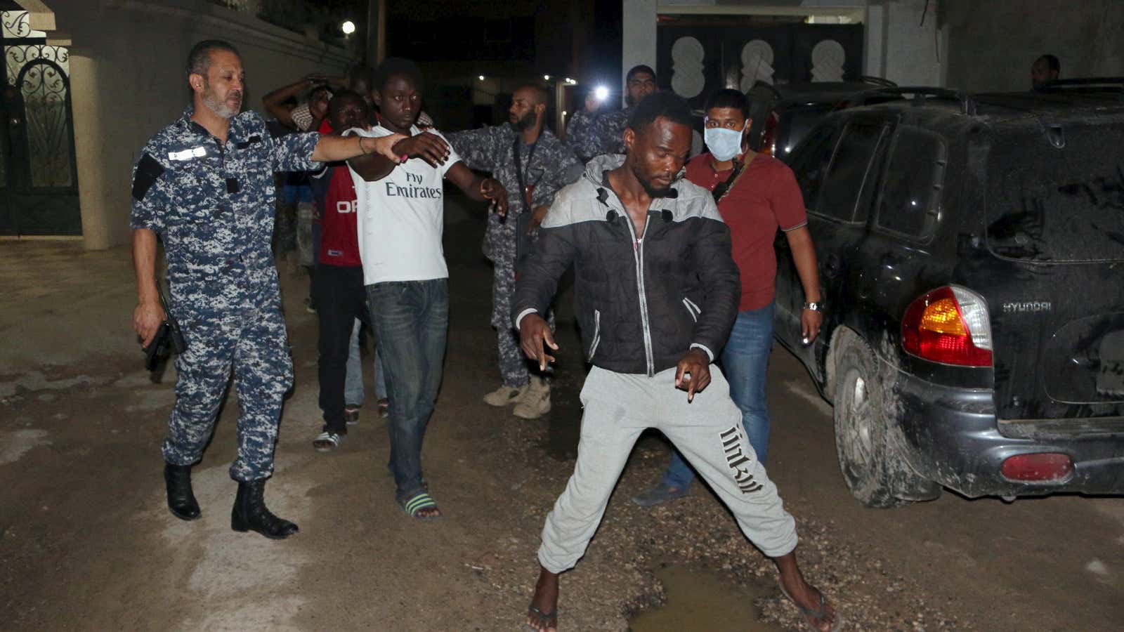 Officers of a Libyan anti-illegal immigrants unit round up migrants at a hideout in Tripoli Libya