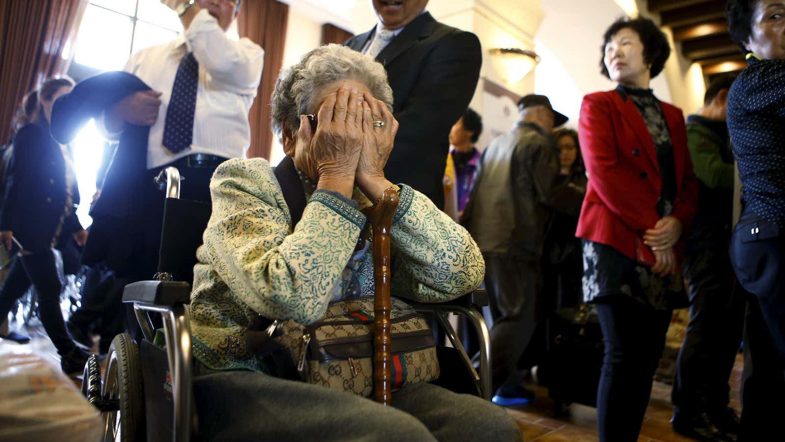 A woman, who is selected as a participant for a reunion, reacts at a hotel used as a waiting place in Sokcho, South Korea.