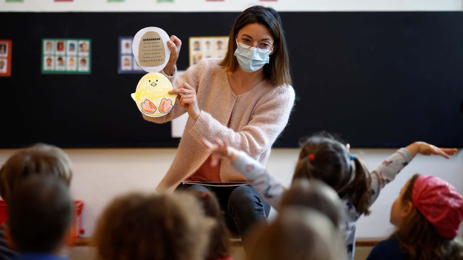 A teacher, wearing a protecive face mask, teaches to schoolchildren in a classroom at a private school in Saint-Sebastien-sur-Loire, as France will start its third…