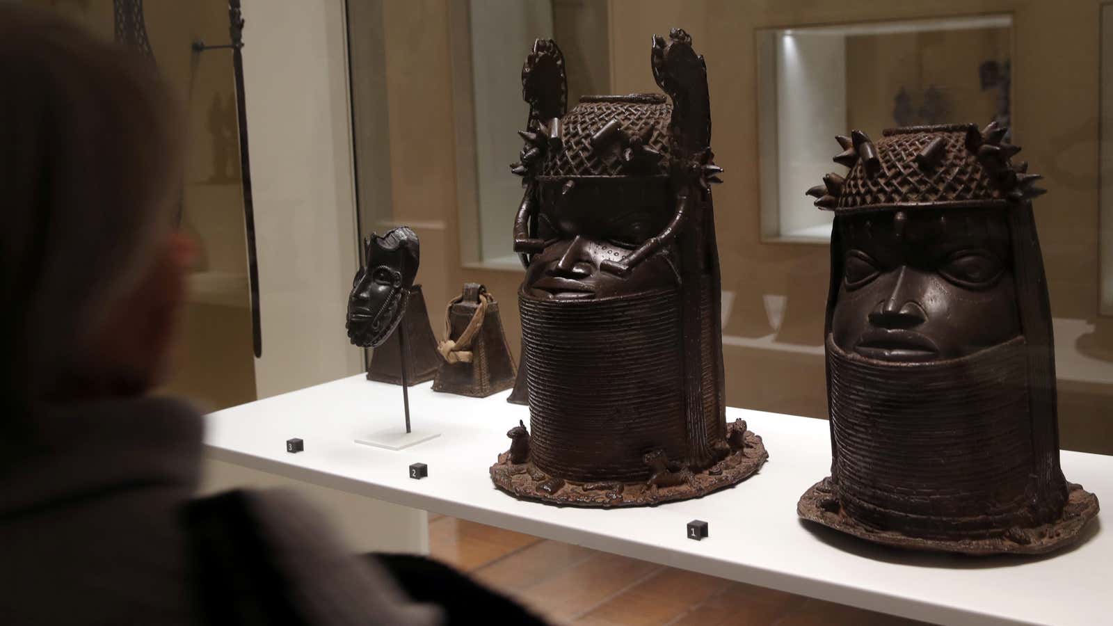 Two heads of a royal ancestor (Uhunmwun Elao), from the former Benin Kingdom, a part of modern-day Nigeria, 18th century (R) and 19th century (C) displayed at the Quai Branly Museum in Paris,