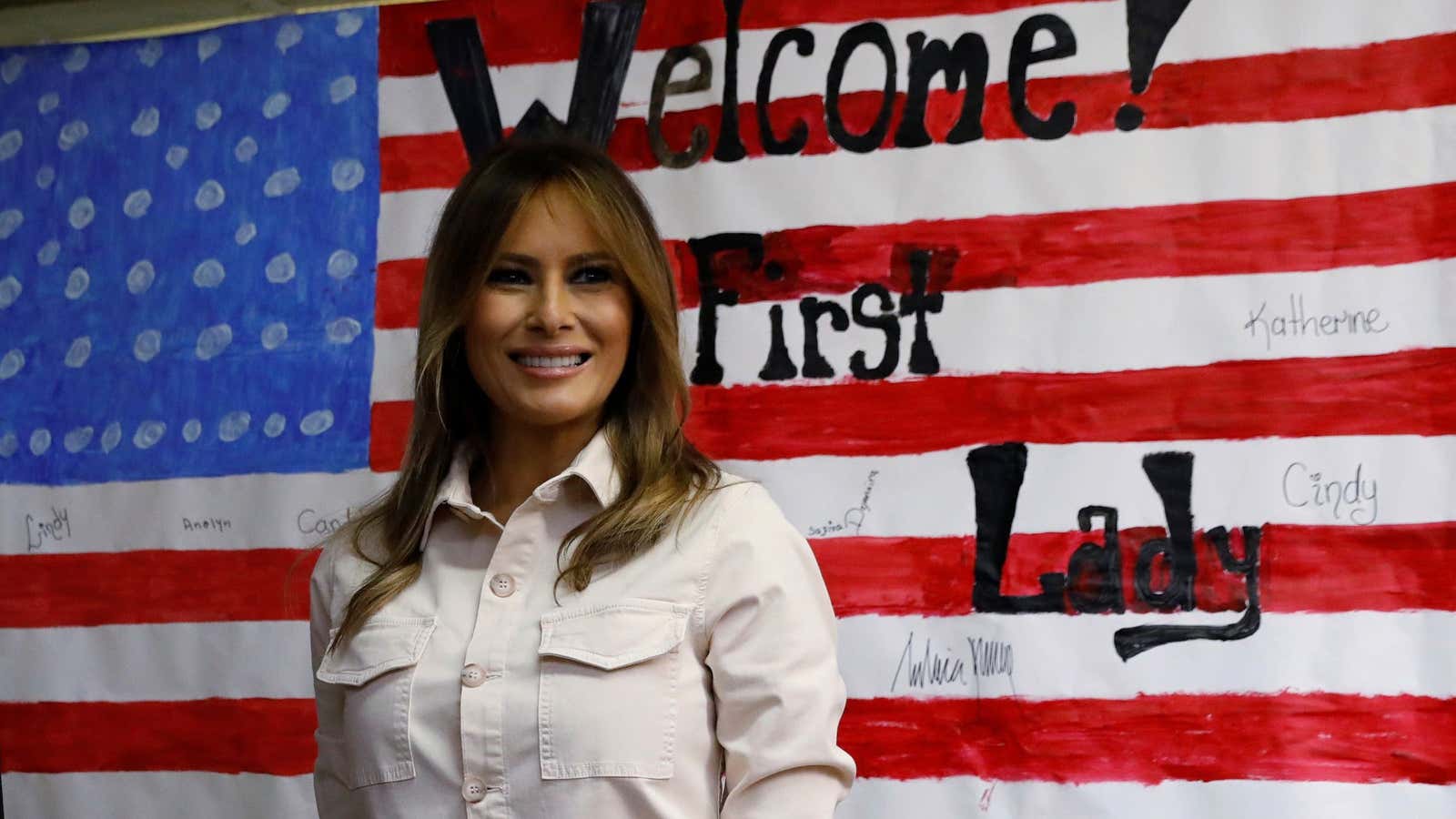 U.S. first lady Melania Trump poses in front of a U.S. flag after touring the Lutheran Social Services of the South “Upbring New Hope Children’s Center”
