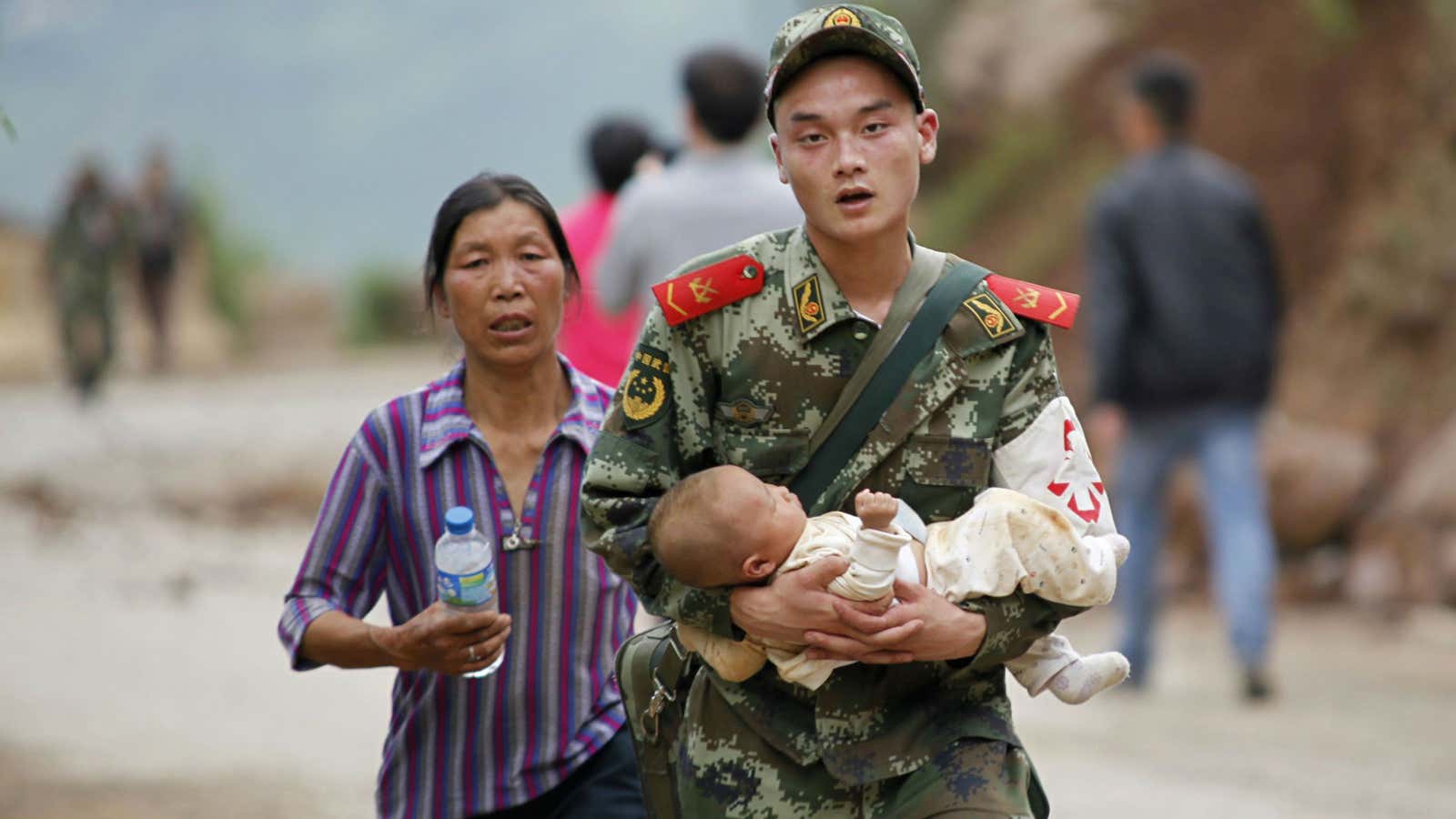 A policeman carries a baby after an earthquake hit southwest China on Sunday, killing at least 381 people.