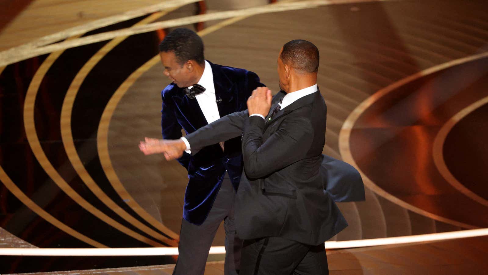 Will Smith (R) hits at Chris Rock as Rock spoke on stage during the 94th Academy Awards in Hollywood, Los Angeles, California, U.S., March 27,…