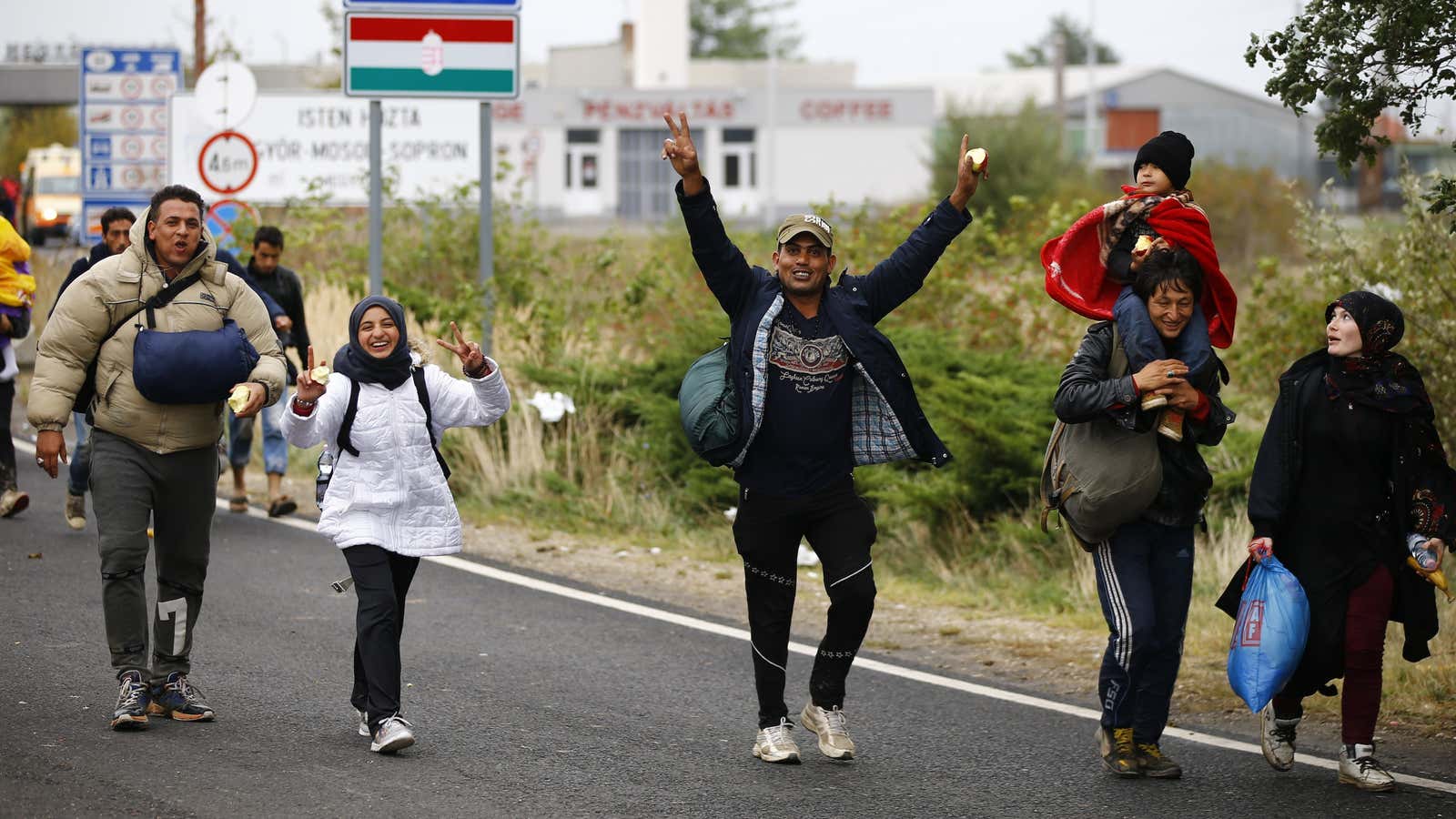 Refugees celebrate as they cross the border from Hungary into Austria in Sep. 2015.