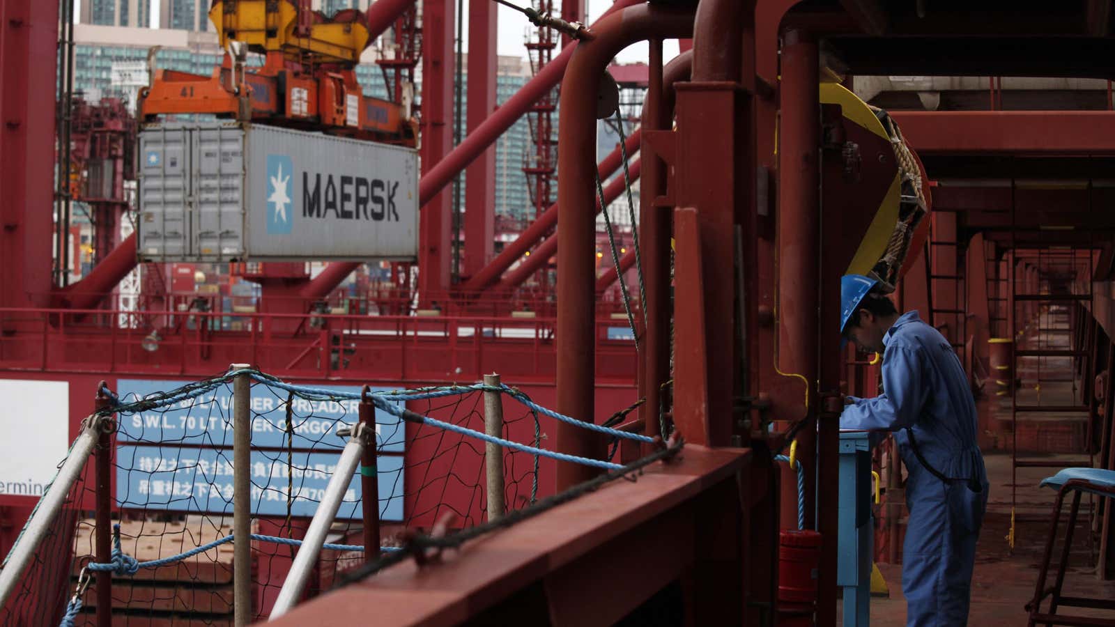 A crew member works as cargo is unloaded from Emma Maersk, one of the world’s largest containers.