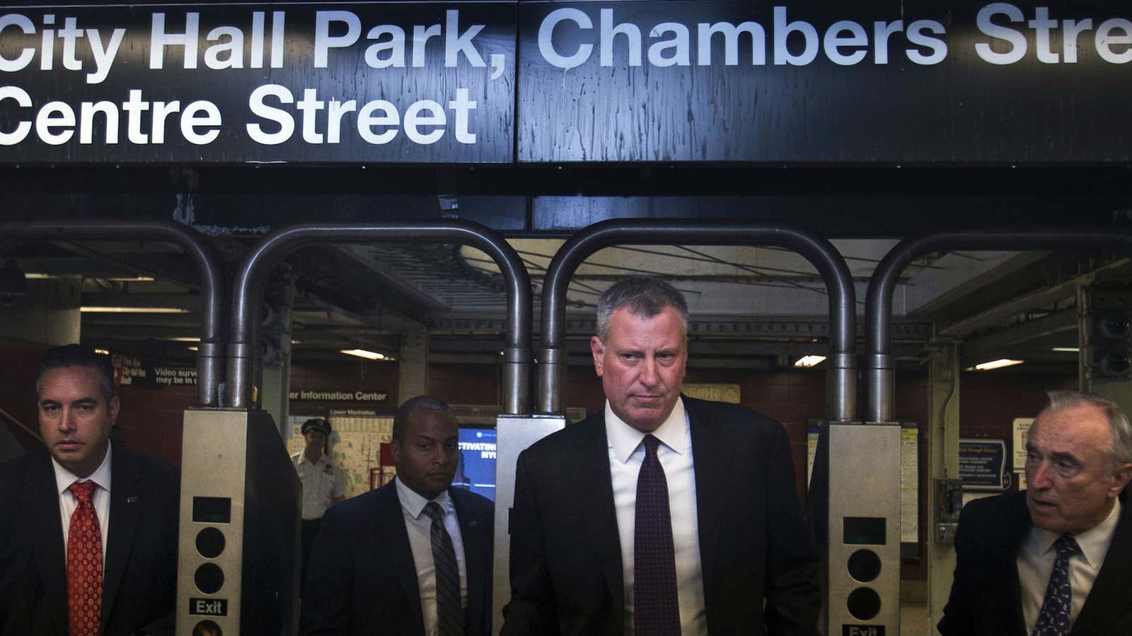 New York City Mayor Bill de Blasio (second from the right) and police commissioner William Bratton emerge from the subway for a press conference.
