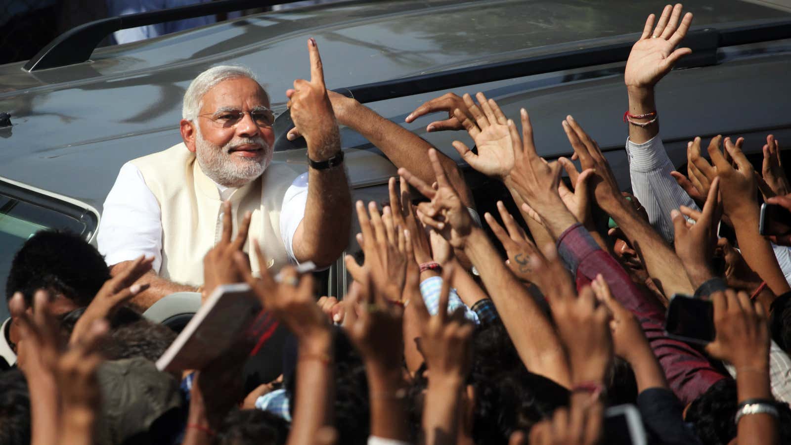 Modi shows his inked finger after voting to a crowd in Ahmadabad, India.