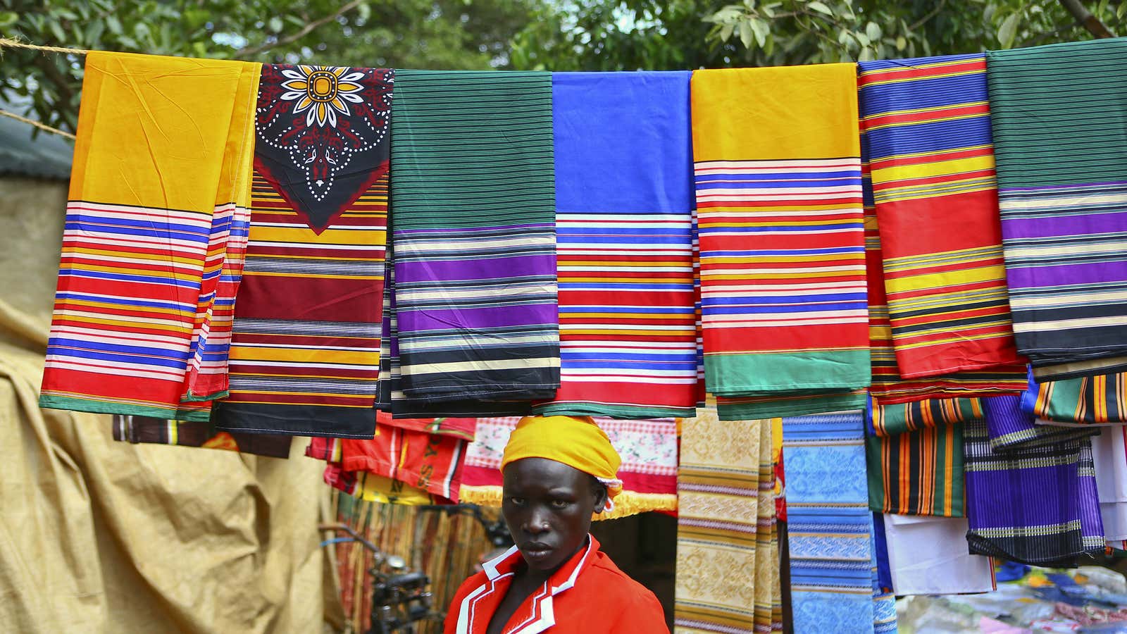 A trader from Bunia in eastern Democratic Republic of Congo sells fabric at a market at the Kyangwali refugee settlement in Hoima district in Western Uganda