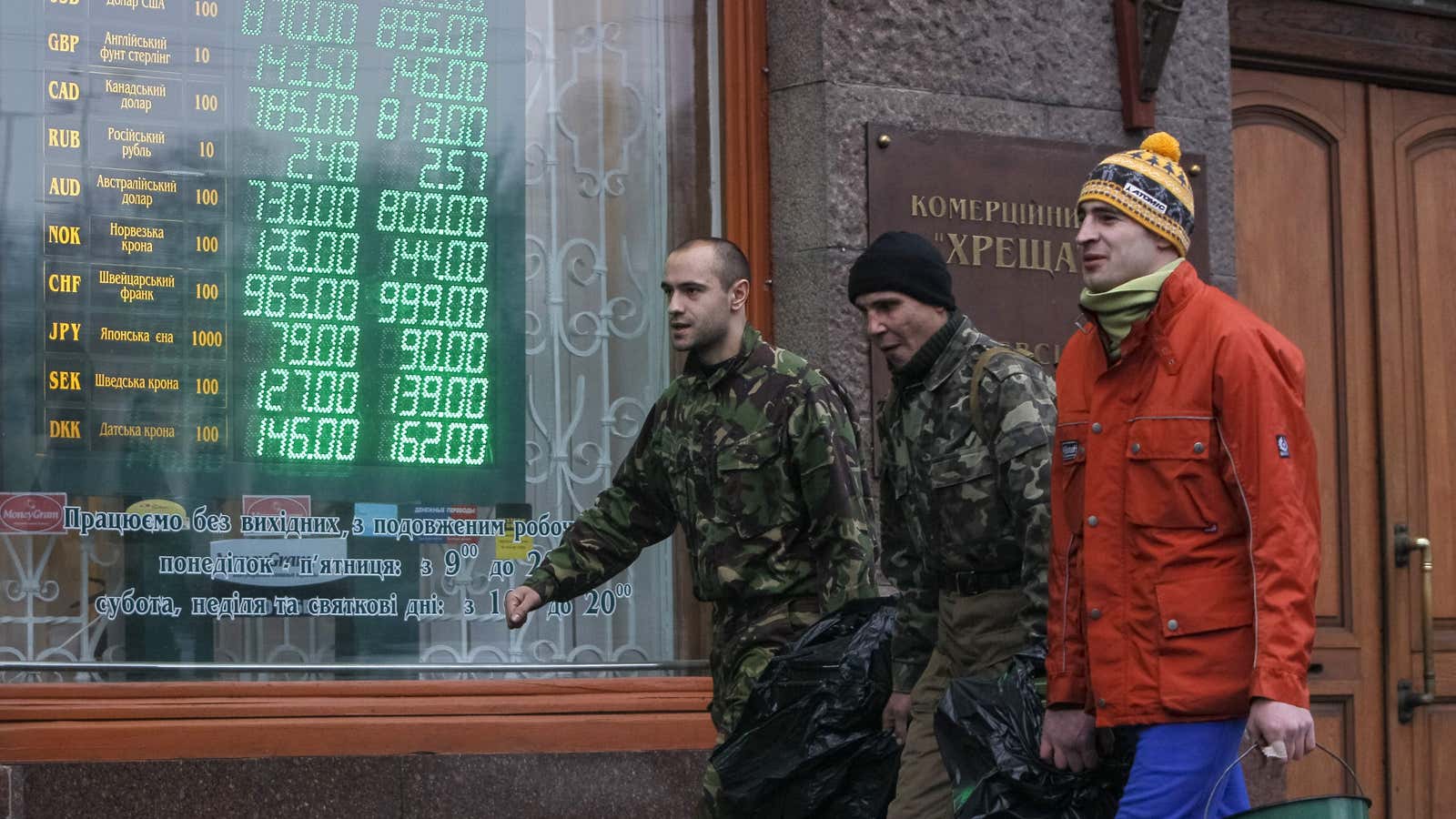Anti-government demonstrators walk past a currency exchange office in Kiev February 7, 2014. Ukraine’s central bank tried to dampen fears about its currency on Friday…
