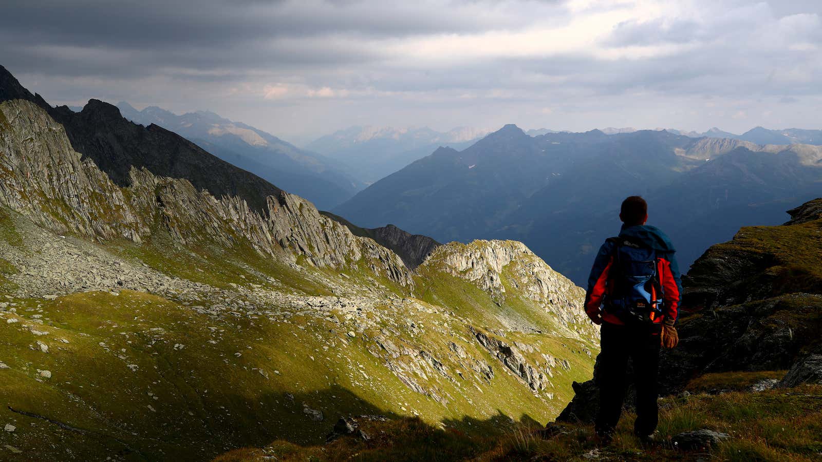 A hiker looks at a mountain range at the Hohe Tauern National Park near the village of Virgen, Austria, July 23, 2018. Picture taken July…